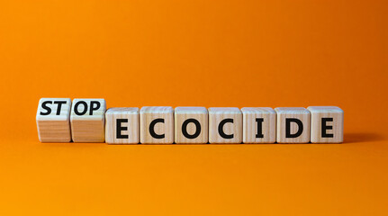 Stop ecocide symbol. Turned wooden cubes with words stop ecocide. Beautiful orange background, copy space. Business, ecological and stop ecocide concept.