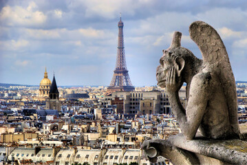 Famous Notre Dame gargoyle overlooking the Paris cityscape with Eiffel Tower  - Powered by Adobe