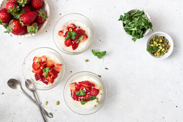 Healthy dessert of natural yogurt with strawberries and pistachios