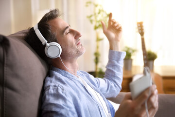 Man on the couch at home listening to music placidly