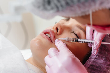 Cosmetology procedure for lip augmentation and wrinkle removal for a young beautiful girl....