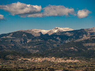 panoramic view of the village of Campanet with the snow covered Puig Major in the Background on the balearic island of mallorca, spain