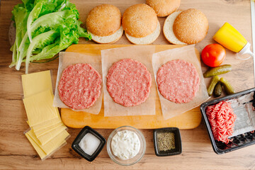 Ingredients for making burgers. Cooking burgers. Burger cutlets on a wooden board. Making burgers in your home kitchen