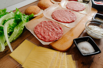 Ingredients for making burgers. Cooking burgers. Burger cutlets on a wooden board. Making burgers in your home kitchen