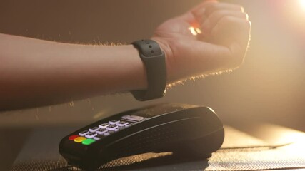 Person pays in a cafe using an electronic smartwatch. Contactless technology NFC. Consumerism internet online purchases. Man is Paying with a Smart Watch - Powered by Adobe