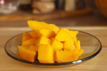 Mango cut into small pieces on a plate. Healthy food concept. Beautiful exotic fruit. Food background.