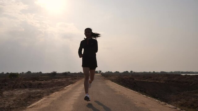 The silhouette of a girl jogging in the evening