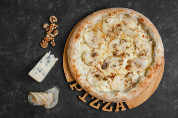 Homemade pizza with pear, gorgonzola, walnuts and honey on a dark background. Top view, side view