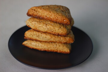 Home baked plain mildly sweet buttermilk scones, four of them stacked on a grey plate.