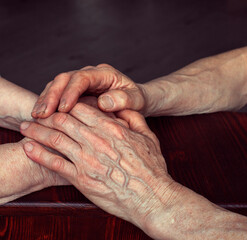 the older man holds the woman's hands