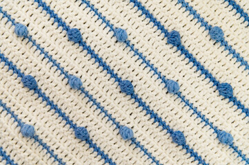 Crochet product from multicolored threads. Handmade backdrop. Fragment of a plaid of blue and ivory tone. Striped, geometric pattern. Flat lay 15 ball