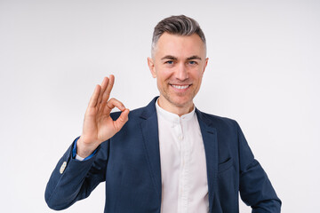 Successful caucasian mature businessman showing okay sign isolated in white background