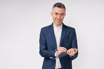 Confident mature businessman writing on clipboard isolated over white background