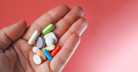 handful of pills in hand close-up
