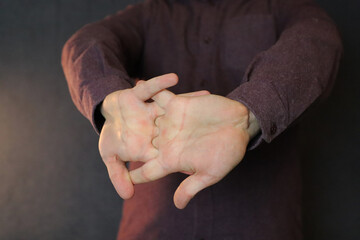 male hands in a shirt on a dark background