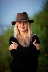 blonde girl in a hat in nature, selective focus