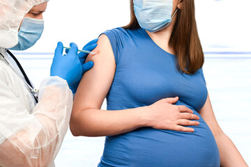 Pregnant Vaccination. Doctor giving COVID -19 coronavirus vaccine injection to pregnant woman....