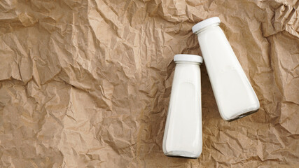 Organic cow milk in glass bottles. Two bottles of milk on crumpled craft paper