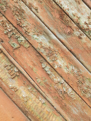 textured background of old time-worn wooden planks, set at an angle of 45 degrees, from a mixture of red, white and brown colors, siding of a wood panel of an old house, close-up, no people, patern. 