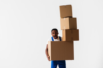 A delivery man wearing a white T-shirt and blue pants holds boxes in his hands. Isolated on a white background. Concept of delivery, mail, shipment, loader, courier. Box close up. Sign language