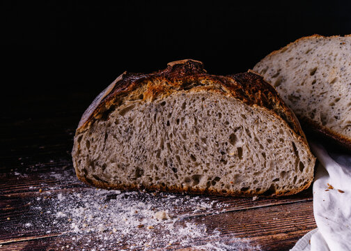 Slices of baked bread placed on wooden table in kitchen