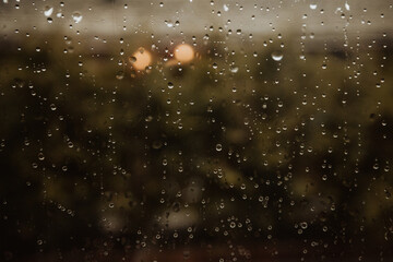 Textured backdrop of translucent wet glass with pure water drips in evening in rainy weather