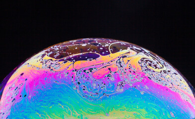 Panoramic view of closeup bubble textured backdrop representing colorful planet with wavy lines on round shaped surface on black background