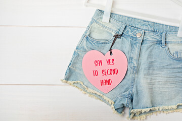 White rack with heart tag and jeans shorts. Slow fashion concept mockup