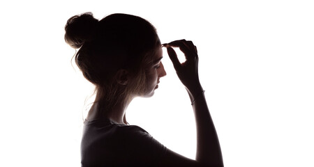 profile silhouette of a pensive girl with hand on forehead , young woman with hand-picked hair on white isolated background