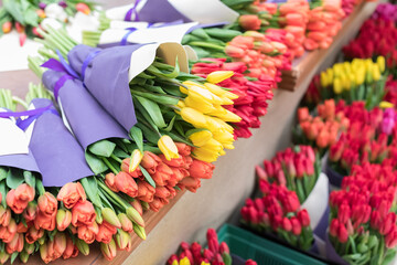 Huge bouquets of different shades of tulips on the counter of a large flower shop. Floral Flower Sales Center,