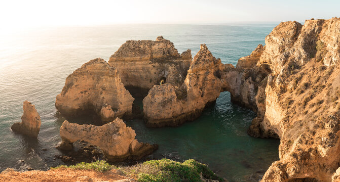 Sea water near bay located on rough cliffs against sundown sky in Ponta da Piedade in Algarve, Portugal