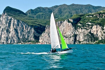 Sports sailing yacht on the high seas. Yacht sailing to the shore on a bright sunny day. Yachting in the sea. Yachting sport. Ocean regatta on sailing yachts. Nautical lifestyle. Freedom concept.
