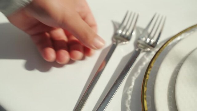 A hand serves a wedding table with fork