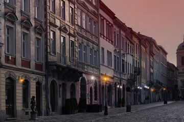 Fragment of the old city. Red sky. Sunrise or sunset. Street lights are shining