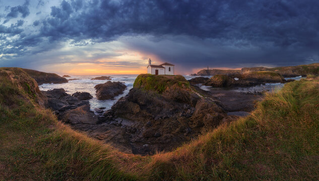 Spectacular landscape of island of Pancha with small house against cloudy sundown sky in Ribadeo in Spain