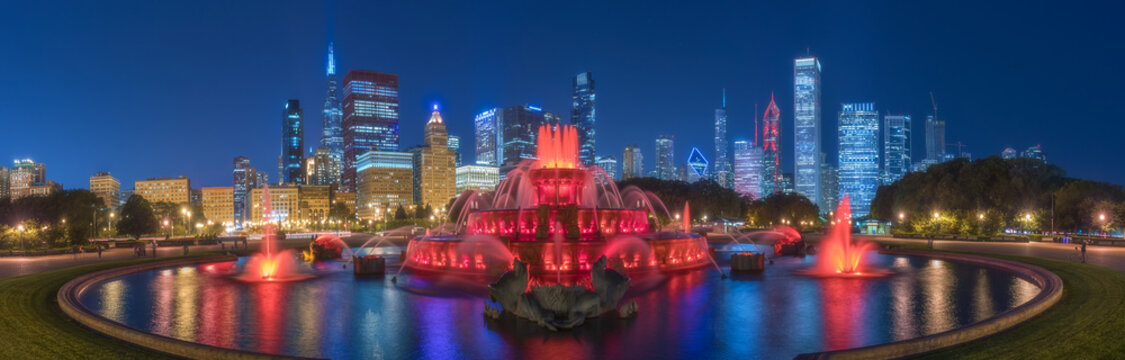 Panoramic cityscape with famous Buckingham Fountain illuminated by colorful lights against contemporary skyscrapers in night time in Chicago