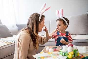 Happy son and mother preparing creative eggs. Mother and son painting Easter eggs. Easter fun and joy. Young mother teaching little son to dye Easter eggs