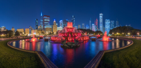 Panoramic cityscape with famous Buckingham Fountain illuminated by colorful lights against contemporary skyscrapers in night time in Chicago