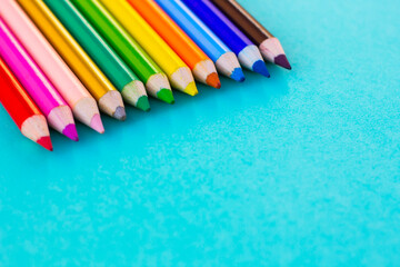 Many different colored pencils with turqoise background