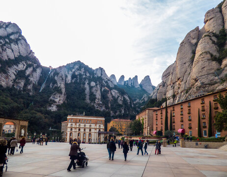 Personas paseando por la explanada del Monasterio de Montserrat (Espa&ntilde;a), con las impresionantes monta&ntilde;as al fondo