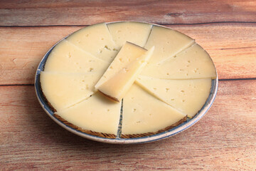 Plate with portion of semi-cured sheep's cheese cut into wedges
