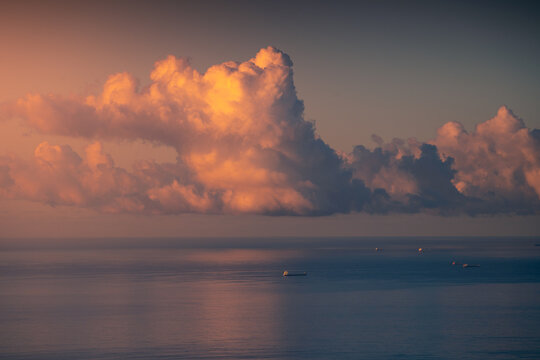 Boats floating in calm sea under sky with clouds illuminated by sunset sun in Cadiz - Powered by Adobe