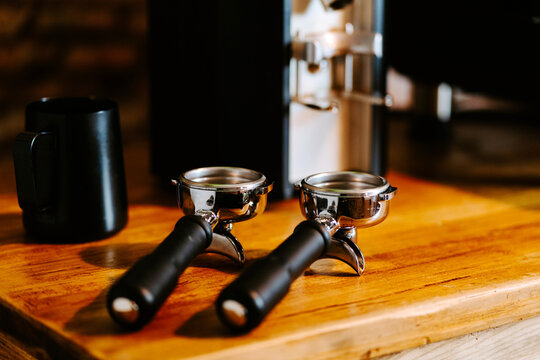 Portafilters placed on wooden table in cafe