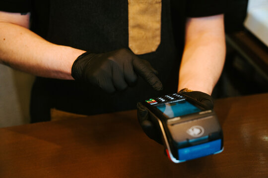 Unrecognizable person holding a credit card and paying at a pos