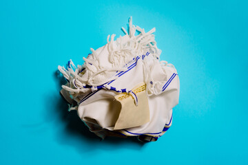 Top view of creased shawl with striped ornament representing trip concept on bright background