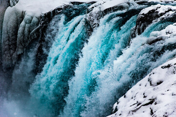 Majestic view of rapid waterfall flowing down rocky mountain in winter in Iceland