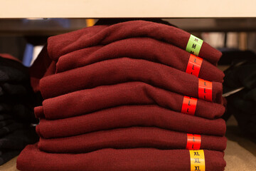 A Knitwear, a stack of red sweaters, clothing