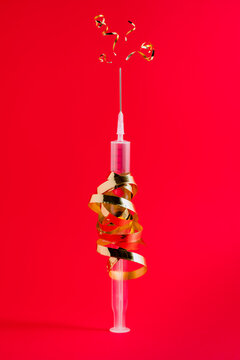Plastic injector with curved golden ribbon and pointed needle representing firework concept during festive event