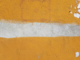 Bright orange wall with white horizontal stripe in the middle, outdoors during the day. Abstract background for text. Warning color, careful, possibly dangerous. Dirty wall with scraps and scratches.
