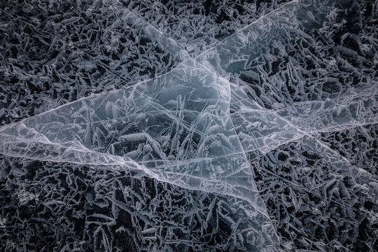 From above of frozen Lake Baikal surface with chaotic pattern and cracks as abstract background